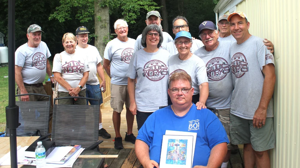 A team of volunteers with a home owner at the conclusion of a Good Works project
