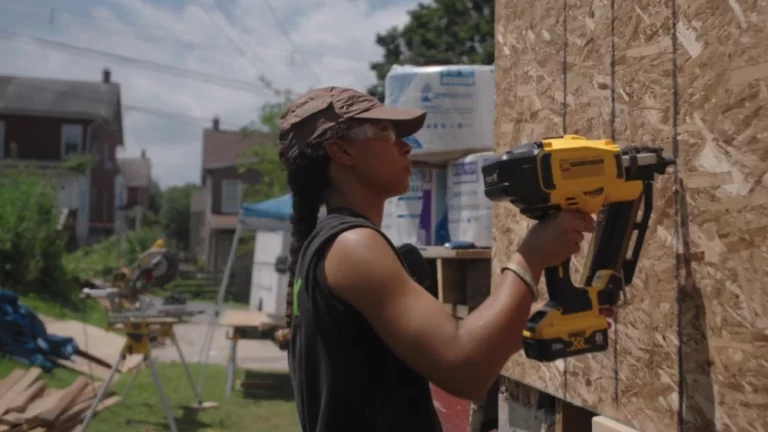 A young Black woman working to repair a home.